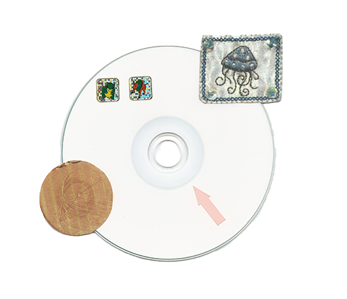 Scanned CD-ROM with tree ring, jellyfish and Pokemon stickers.